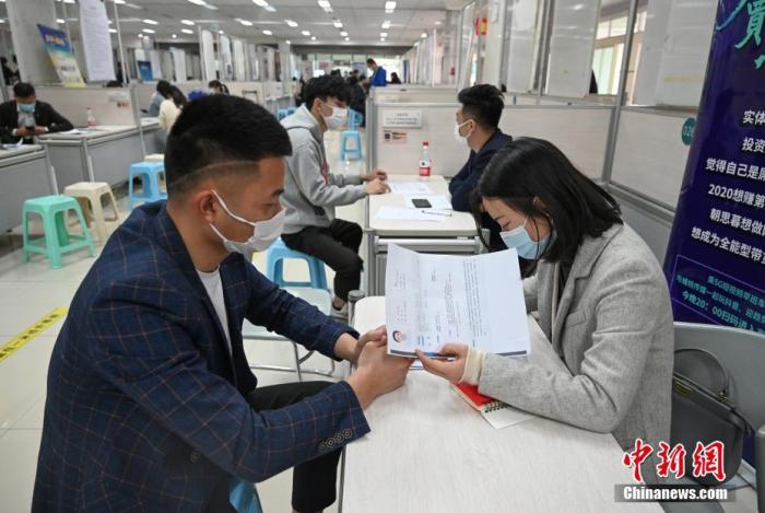 4月14日，招聘者在查看求職者簡歷。<a target='_blank'  data-cke-saved- >中新社</a>記者 王剛 攝