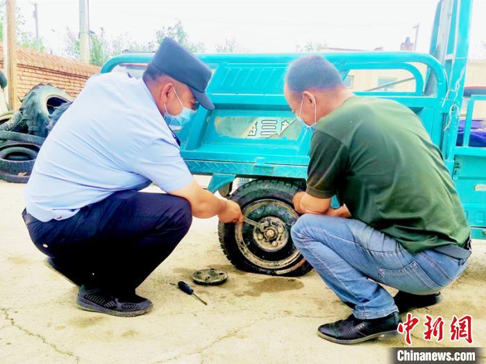 賽旦與民警共同維修三輪摩托車?！∫懒窘?攝