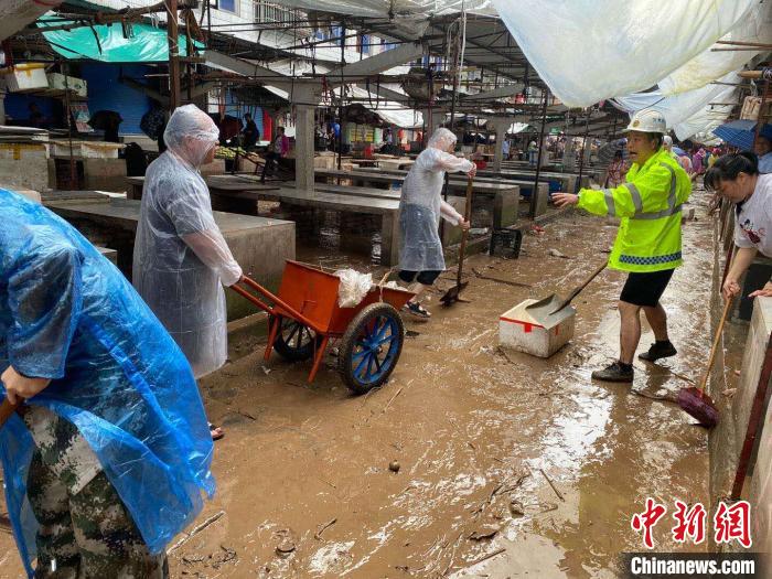 圖為7月26日，暴雨引發(fā)的洪水過境后，重慶萬州區(qū)分水鎮(zhèn)政府干部職工及志愿者清掃淤泥和垃圾?！　≈貞c萬州區(qū)委宣傳部供圖 攝
