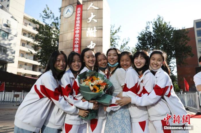 資料圖：6月10日，在北京人大附中高考考點(diǎn)外，考生們相擁拍照留念。當(dāng)日，北京市2021年高考結(jié)束?！?<a target='_blank'  data-cke-saved- ><p  align=
