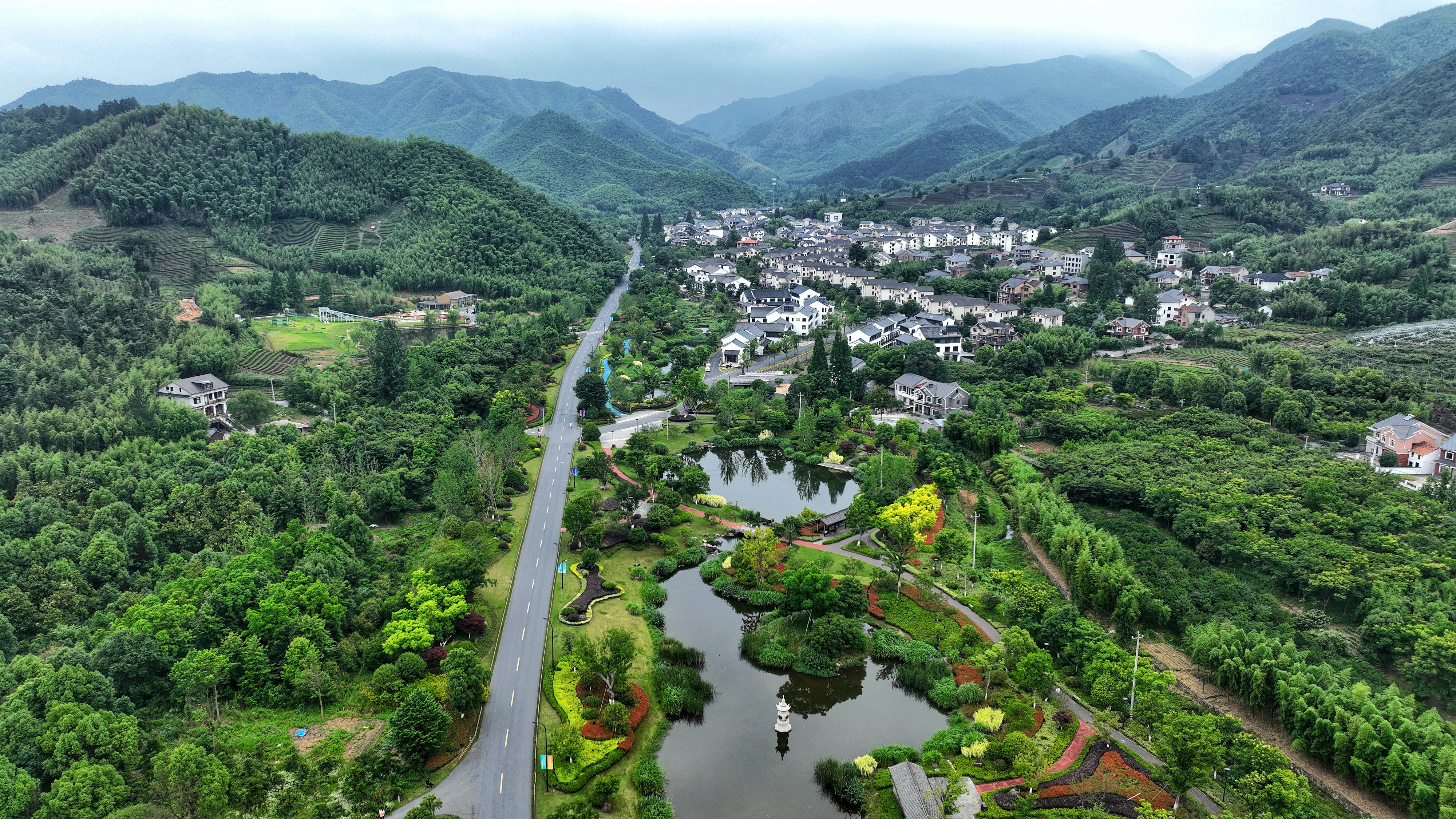 2023年6月6日，杭州余杭區(qū)徑山鎮(zhèn)鄉(xiāng)村，生態(tài)碧水、沿路花海與村莊農(nóng)房相映成趣，構(gòu)成一幅美麗的山水田園畫。