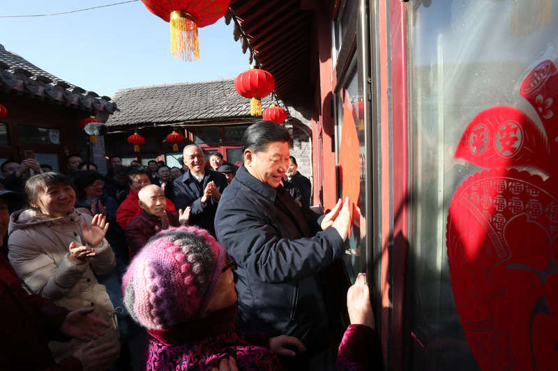 2019年2月1日上午，習(xí)近平在北京前門東區(qū)草廠四條胡同32號院，高興地拿起一幅“?！弊?，親自貼到門上，給這里的老街坊們拜年。新華社記者 鞠鵬 攝