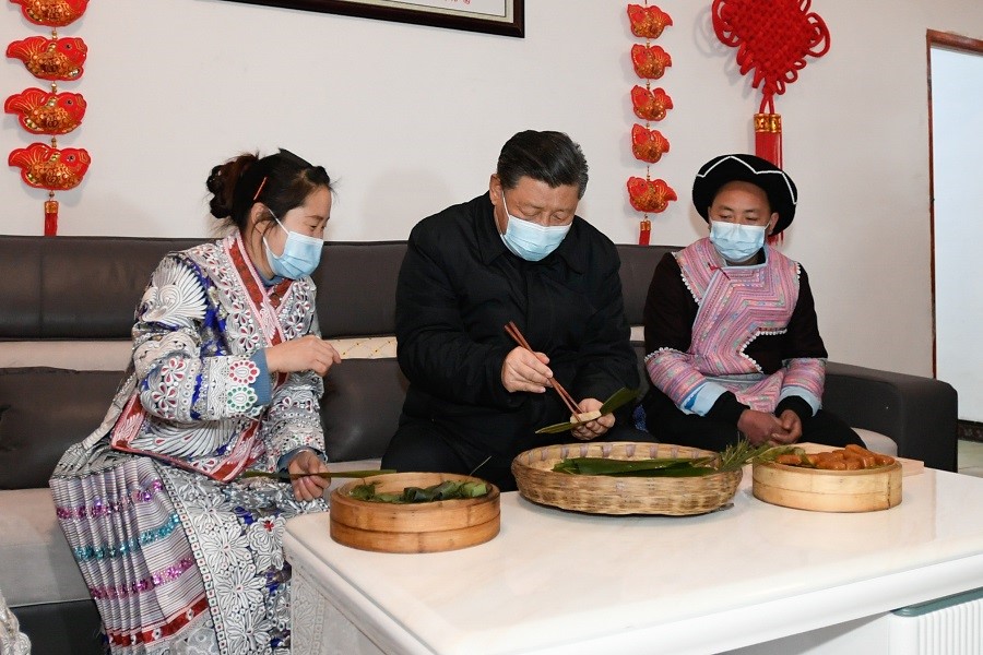 2021年2月3日下午，習(xí)近平在貴州畢節(jié)市黔西縣新仁苗族鄉(xiāng)化屋村苗族村民趙玉學(xué)家，同一家人邊聊家常邊制作當(dāng)?shù)貍鹘y(tǒng)節(jié)日食品黃粑。新華社記者 李學(xué)仁 攝